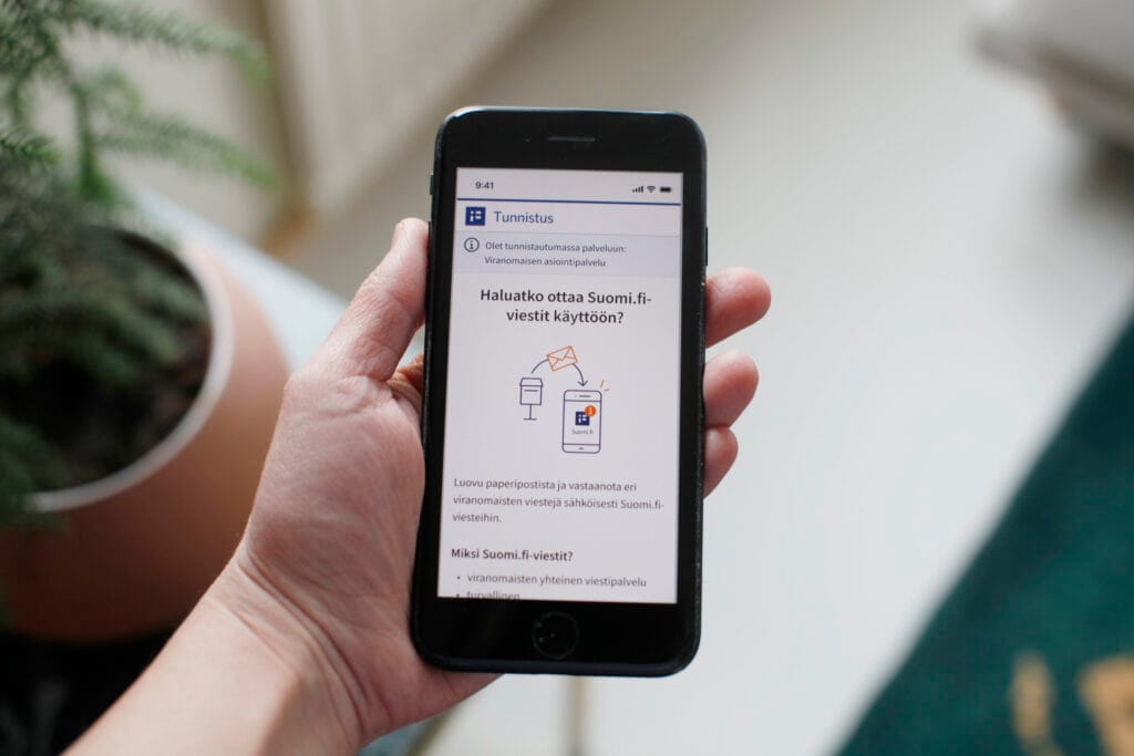 Henkilö pitää puhelinta kädessään.