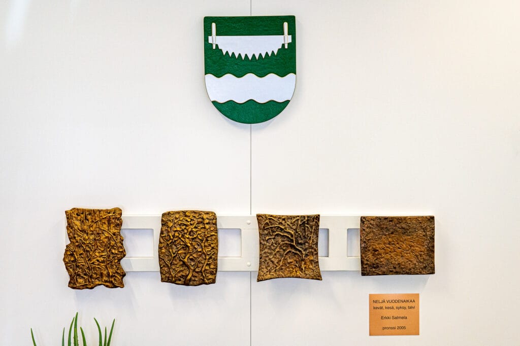 Ranuan kunnan vaakuna ja taideteos Ranuan kunnanviraston aulassa.