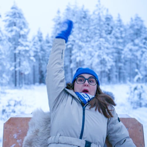 Nainen jäisessä metsässä, vauhdikkaassa rekikyydissä.