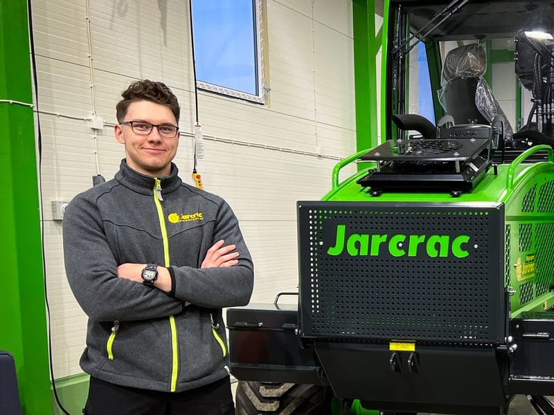 Jere Konttila seisoo hallissa olevan Jarcrac pienmetsäkoneen vieressä
